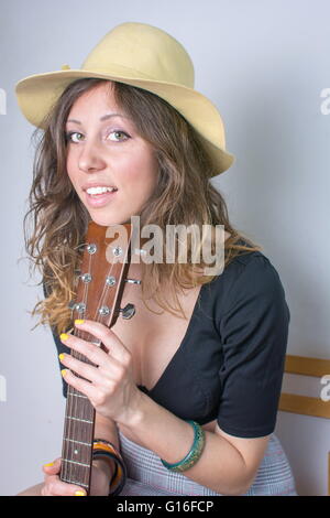 Attraktive junge Frau mit einer Gitarre Stockfoto