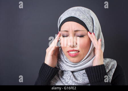 Muslimische Frau, die Kopfschmerzen Stockfoto