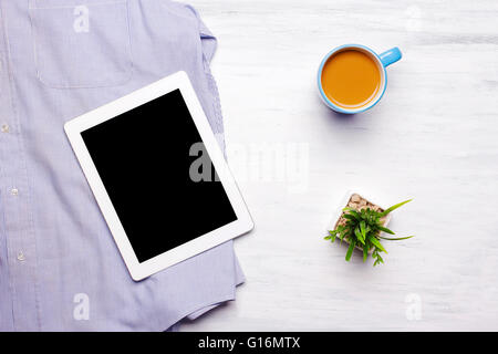 Geschäftsmann Outfit und alltägliche Gegenstände auf weißem Hintergrund aus Holz. Tablet-Gadget mit Exemplar über Mannes Kleidung. Stockfoto