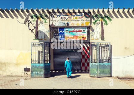 Eine Frau trägt traditionelle Kleidung, die einen Markteintritt. Fez, Marokko. Stockfoto