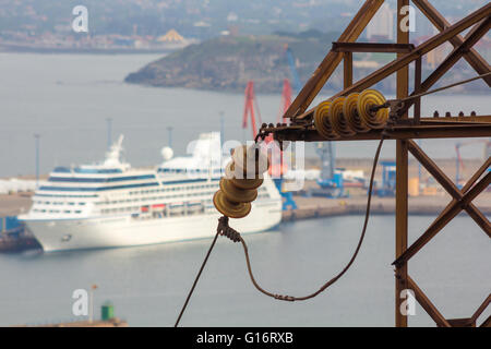 Alt und rostig elektrischer Turm mit einem Boot im Hintergrund Stockfoto