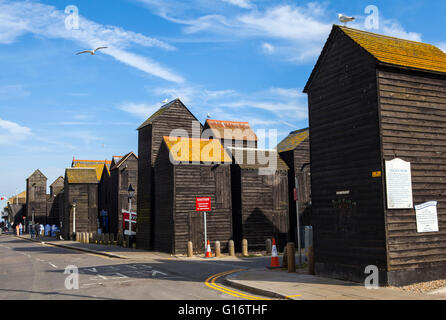 Ein Blick auf die hölzerne Angeln wirft und Net Geschäfte direkt am Meer in Hastings, Sussex. Stockfoto