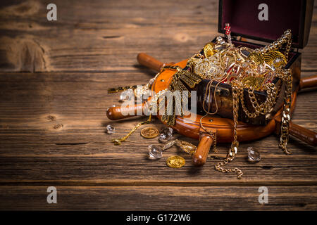 Piraten Truhe mit Goldschmuck auf hölzernen Hintergrund Stockfoto