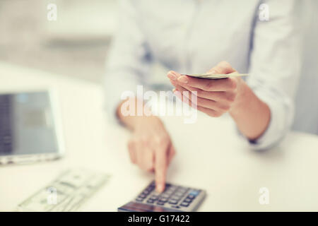 Nahaufnahme von Frau Geldzählen mit Taschenrechner Stockfoto