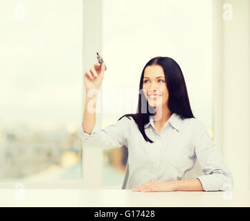 lächelnde Frau schreiben auf virtuellen Bildschirm Stockfoto