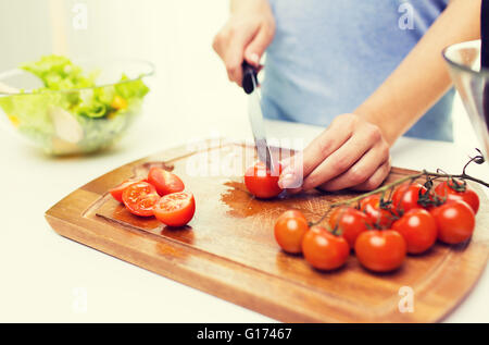 Nahaufnahme von Frau hacken Tomaten mit Messer Stockfoto