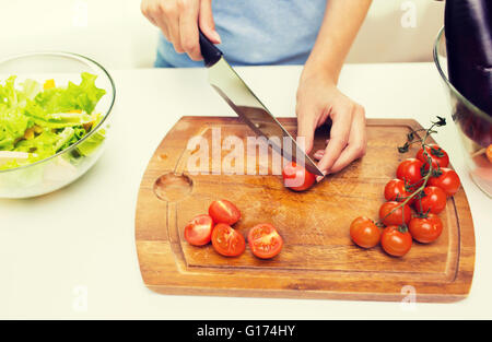 Nahaufnahme von Frau hacken Tomaten mit Messer Stockfoto