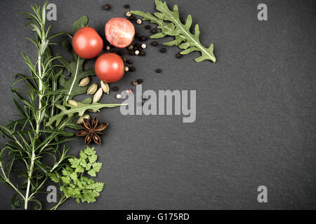 Frische Kräuter und Gewürze auf grauem Schiefer dunkel Stockfoto