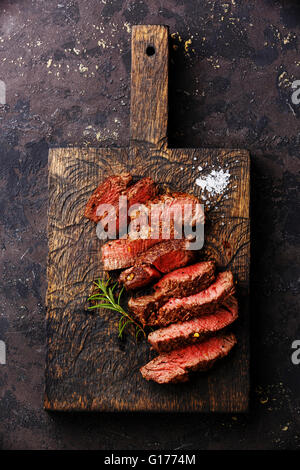 Roastbeef in Scheiben gegrilltes Steak und Rosmarin auf hölzernen Cutting Board Hintergrund Stockfoto