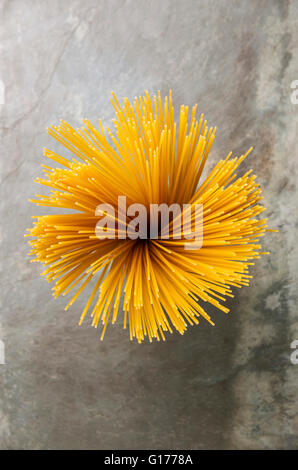 Draufsicht Blütenform Bündel Spaghetti auf grauem Stein Schiefer Hintergrund Stockfoto