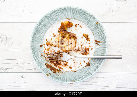 Overhead Schuss einen leeren Teller mit Resten von einer Mahlzeit auf einem weißen Hintergrund Holz Stockfoto