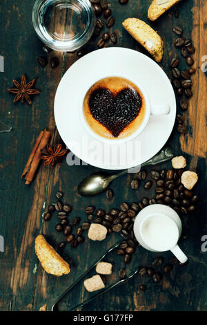 Tasse Kaffee mit Herz auf Schaum und einige Zutaten Stockfoto