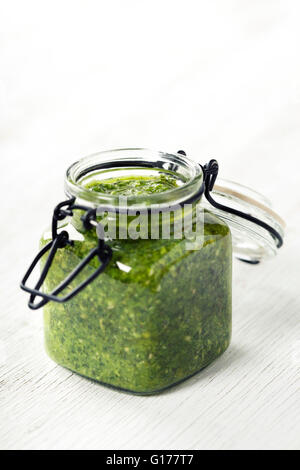 Hausgemachte traditionelle Basilikum-Pesto auf einem rustikalen Holztisch Stockfoto