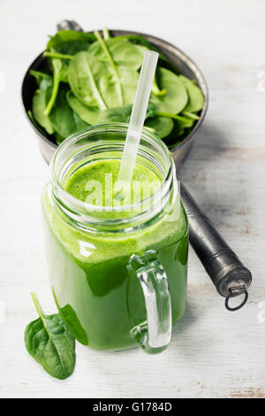 Gesunden grünen Smoothie mit Strohhalm in ein Glas Becher auf weißem Hintergrund Stockfoto