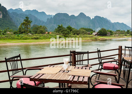 Ansicht des Nam Song Flusses mit Esstisch in Vang Vieng, Laos Stockfoto