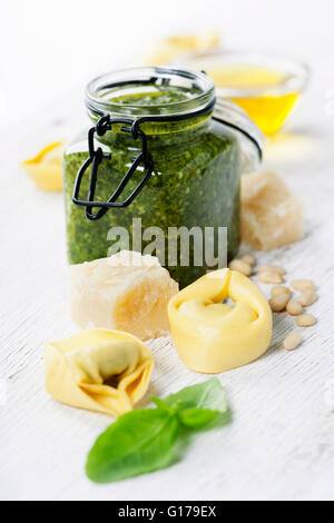 Hausgemachte rohe italienische Tortellini mit Pesto auf rustikalen hölzernen Hintergrund Stockfoto