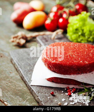 Rohen Boden Rindfleisch Fleisch Burger Steak Schnitzel mit Gewürzen und Gemüse auf Vintage Holzbrettern Stockfoto