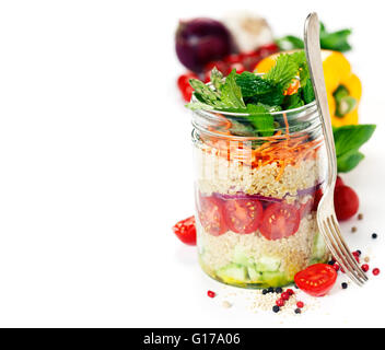 Gurke, Quinoa, Tomate, Zwiebel, Karotte und Minze Salat in einem Glas über weiß Stockfoto