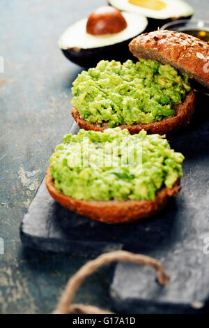 Leckere Avocado-Sandwiches auf Schiefer Hintergrund Stockfoto