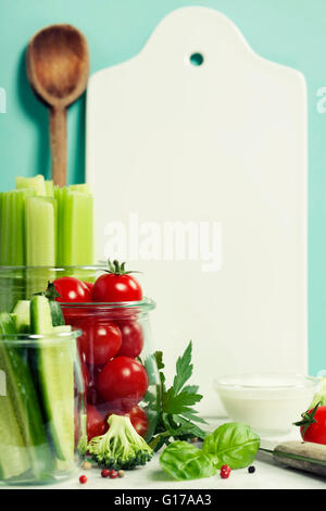 Verschiedene frische Gemüse mit Dip und weißer Keramik mit Board mit Platz für Ihren text Stockfoto