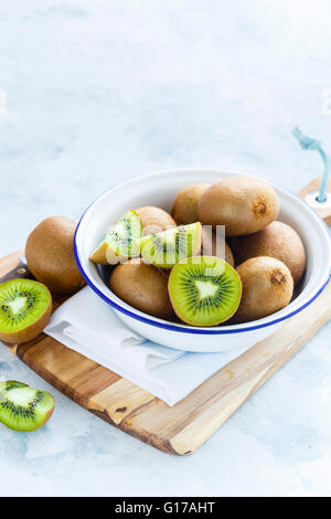 Kiwi-Früchte in eine Schüssel geben Stockfoto