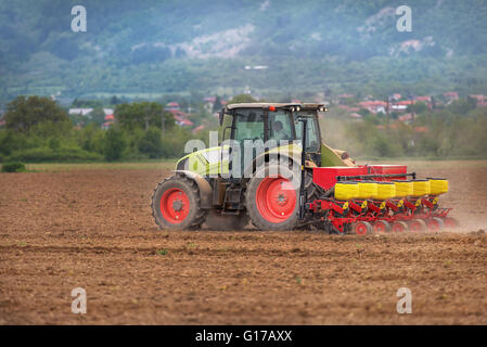 Landwirt in Aussaat Ernte am Feld mit Samen Streuung Landmaschine Traktor. Stockfoto