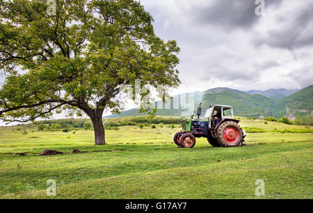 Alte rostige Traktor mit Sturm Wetter im Hintergrund Stockfoto