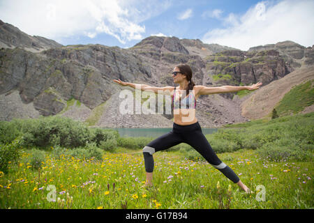 Frau praktizieren Yoga auf Wiese, Cathedral Lake, Aspen, Colorado Stockfoto