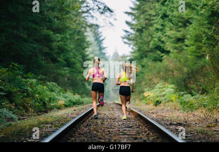 Junge Frau und Teenager-Mädchen, die auf ländlichen train Track, Rückansicht Stockfoto