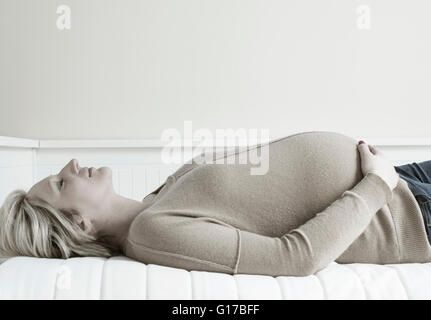 Schwangere Frau auf dem Sofa entspannen Stockfoto