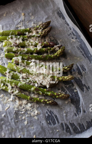 Frischer grüner Spargel vor dem Braten mit geriebenem Parmesan bestreut Stockfoto