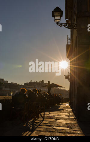 Sommer in der Stadt: Terrasse eines Restaurants mit Kunden sitzen in der Sonne, Porto, Portugal. Stockfoto