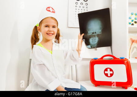 Mädchen in Tracht der Arzt Zahnarzt mit x-ray spielen Stockfoto