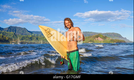 Surfer in Hanalei Bay auf Kauai mit Mt. Makana genannt Bali Hai in Ferne Stockfoto