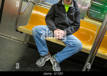 Mann in Beschlag nehmen mehr als einen Sitz (man-Verteilung) auf New Yorker U-Bahn (tube), NYC, USA Stockfoto