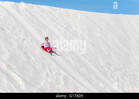 Mädchen Abrutschen Düne in White Sands National Monument, New Mexico. Stockfoto