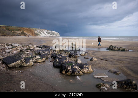 Ein Mann geht seinen Hund am Strand von Yaverland auf der Isle Of Wight Stockfoto