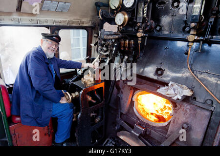 Fracht-Fahrer Colin Henderson auf der Fußplatte von einem Ex-BR 9F Lokomotive 92214 auf der West Somerset Railway, England, UK Stockfoto