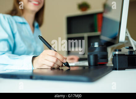 Junge Frau Künstler Zeichnung etwas auf Grafiktablett im home-office Stockfoto