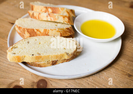 Frisches Brot und Olivenöl auf Teller, Nahaufnahme Stockfoto