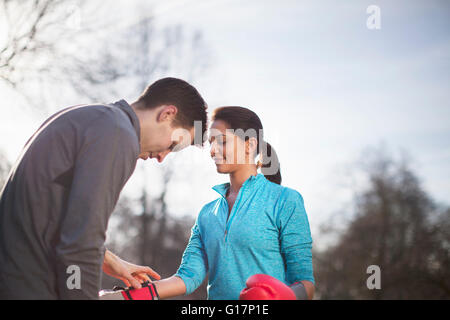 Junger Mann und Frau Befestigung Boxhandschuhe für Training im park Stockfoto