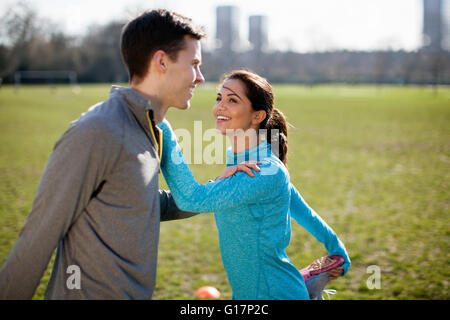 Junge Frau und Mann tut Aufwärmen Stretch Training im park Stockfoto