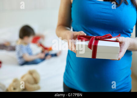 Verkürzte Ansicht schwangere Frau mit Geschenk-box Stockfoto
