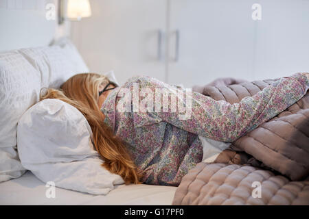 Frau im Schlafanzug im Bett schlafen Stockfoto