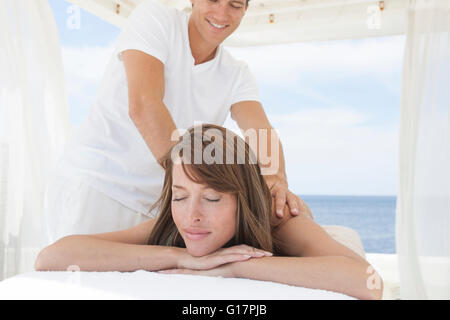 Masseur geben junge Frau eine Schulter massage im Beach Resort, Mallorca, Spanien Stockfoto