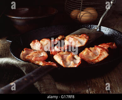 Bacon-Speck in Vintage Pfanne und Eiern im Drahtkorb Stockfoto