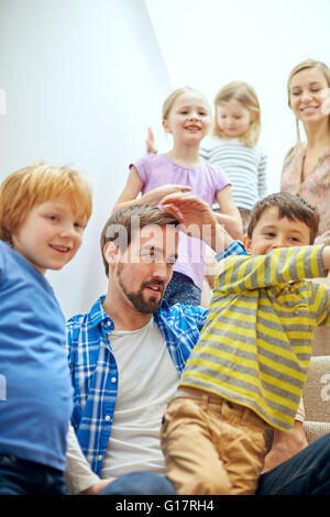 Glückliche Eltern und Kinder sitzen auf der Treppe Stockfoto