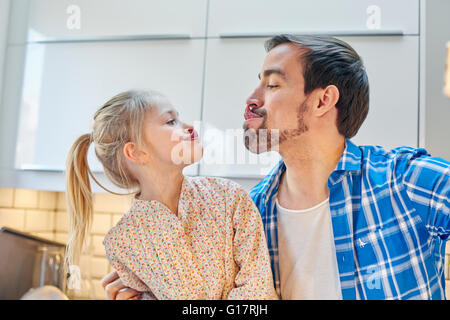 Vater und Tochter nehmen Selfie lustige Gesicht in Küche Stockfoto