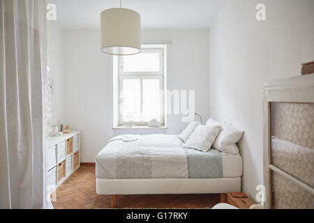 Weiße farbige Schlafzimmer mit Parkettboden, Bett und Schränke Stockfoto