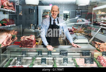 Porträt von Metzger, durch Schaufenster Stockfoto